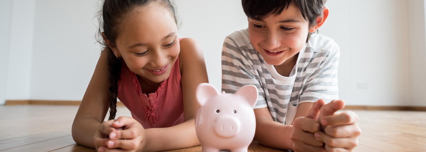 Kids smiling at their piggy bank