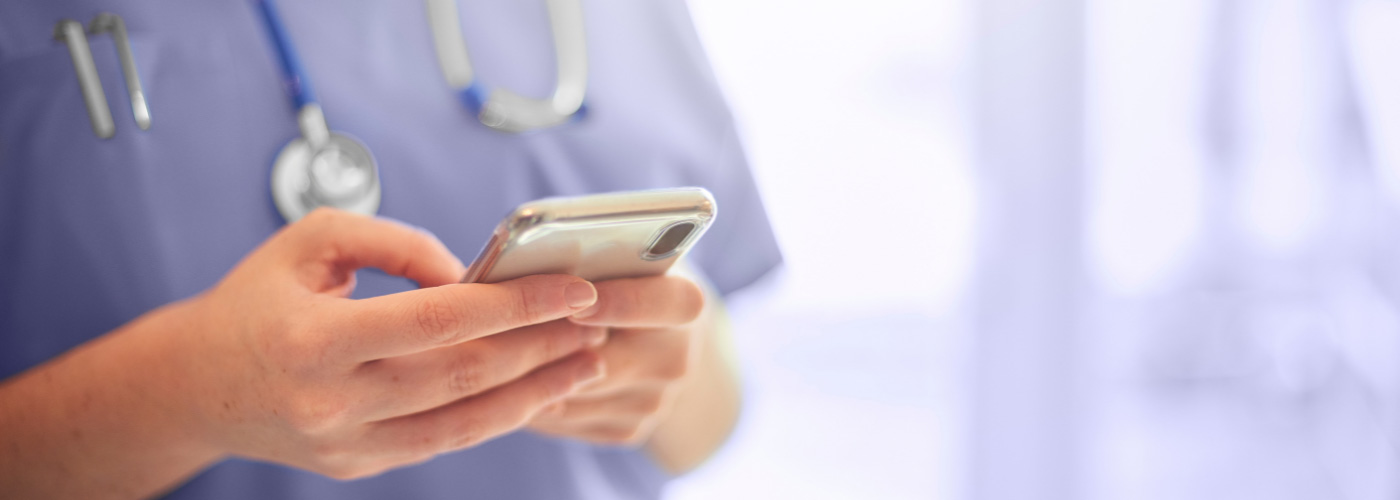 Nurse typing on mobile phone