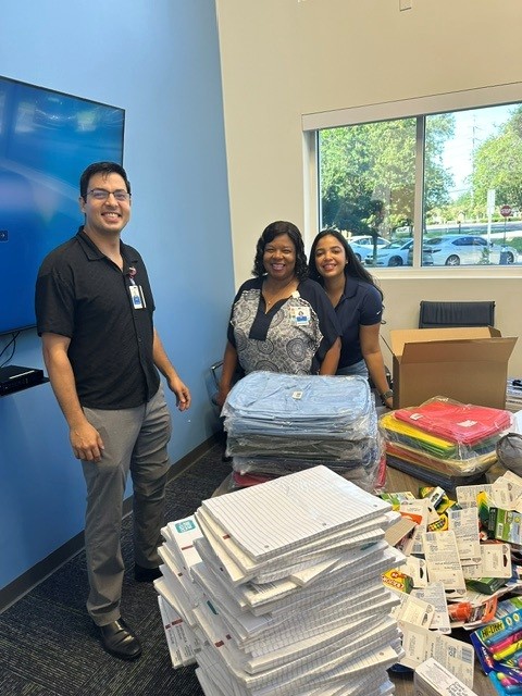 team members at table full of school supplies