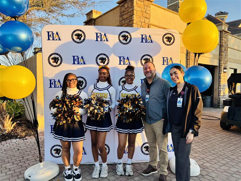 Cheerleaders with credit union team members outdoors