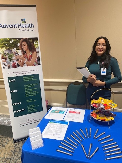 Employee at table set up with credit union materials